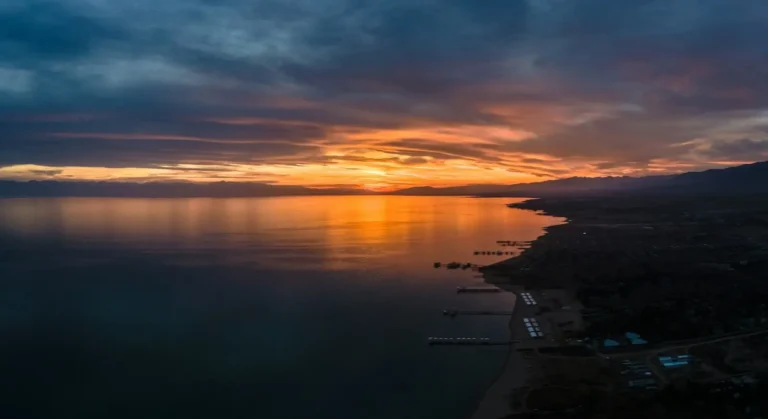 Breathtaking sunset over Issyk Kul Lake with vibrant skies reflecting in the tranquil water