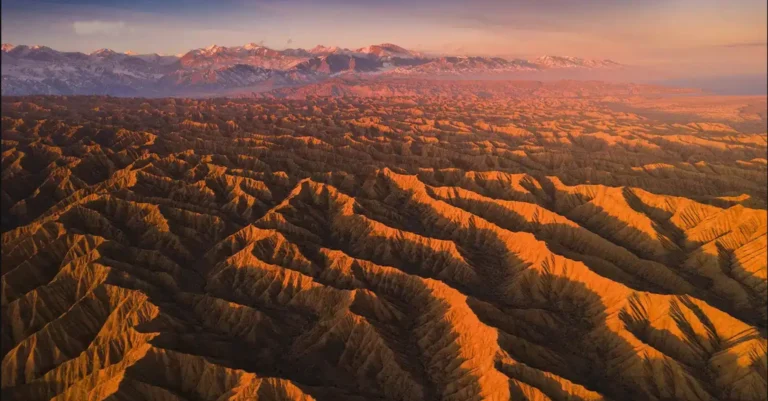 Aerial view of the Canyon of Forgotten Rivers in Issyk-Kul, Kyrgyzstan during sunset, showcasing the textured terrain